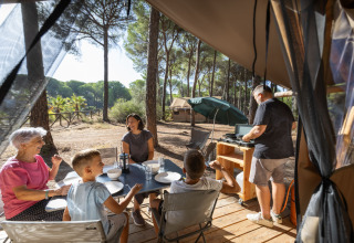 Familie genießt das Glamping auf Huttopia Parque de Doñana, Andalusien, mit Kochen und Entspannung.