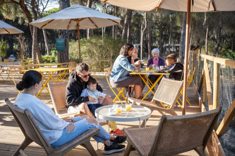 Familia disfrutando desayuno al aire libre en el glamping Huttopia Parque de Doñana en Andalucía, España.