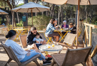 Familie genießt Frühstück im Freien im Huttopia Parque de Doñana Glamping in Andalusien, Spanien.