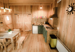 Binnenaanzicht van een boomhut op Recreatiepark d'n Mastendol Brabant met keuken en eetgedeelte.