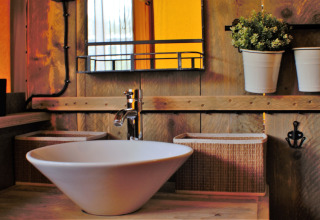 Modernes Glamping-Bad mit Waschbecken bei Ons plekje in het bos - Safarilodges Gelderland, stilvolle Details.