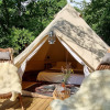 Glamping accommodation at Sävö Bed and Breakfast, featuring a luxurious tent, wooden chairs, and a cozy terrace.