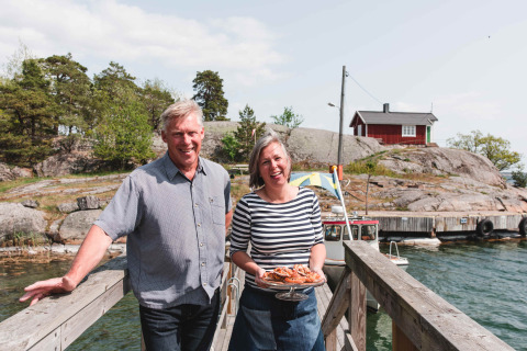 Twee glimlachende personen op de steiger bij Sävö Bed and Breakfast Glampingtenten, Södermanland, Zweden.