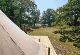 Tente glamping au Sävö Bed and Breakfast en Södermanland, sur terrasse en bois avec vue sur le lac.