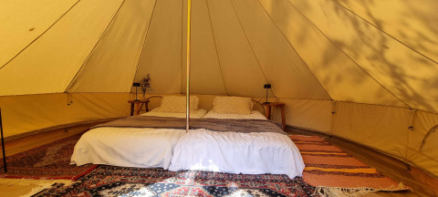 Intérieur d'une tente glamping de luxe au Sävö Bed and Breakfast en Södermanland, Suède, avec lit double.