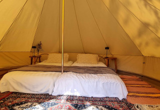 Intérieur d'une tente glamping de luxe au Sävö Bed and Breakfast en Södermanland, Suède, avec lit double.