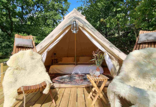 Tenda glamping di lusso con sedie in pelliccia e arredamento accogliente presso Sävö Bed and Breakfast.