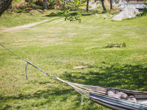 A hammock with pillows in a grassy area at Sävö Bed and Breakfast - Glampingtenten Södermanland, Sweden.