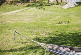 A hammock with pillows in a grassy area at Sävö Bed and Breakfast - Glampingtenten Södermanland, Sweden.