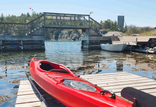 Kayak rojo sobre embarcadero en Sävö Bed and Breakfast - Glampingtenten Södermanland, entorno natural.