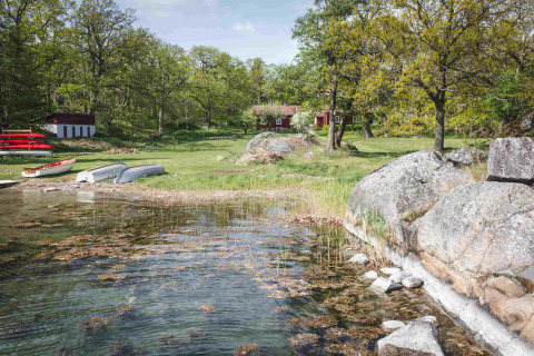 Glamping sul lago con barche, prato verde e casette di legno al Sävö Bed and Breakfast, Södermanland.