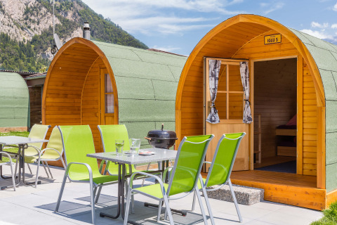 Moderne houten iglo-accommodaties en buitenterras bij Camping Lazy Rancho in de Zwitserse Alpen.