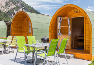 Modern wooden igloo cabins and outdoor dining area at Camping Lazy Rancho glamping site in Switzerland.