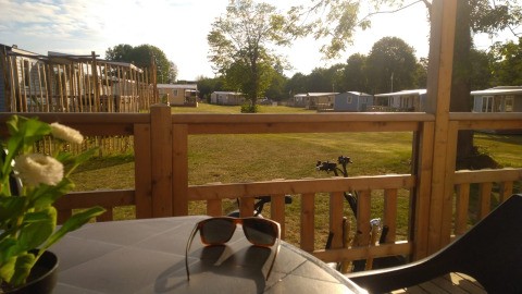 Vista da una terrazza con occhiali da sole sul tavolo al Luxe Camping Borken am See - Glamping NRW.