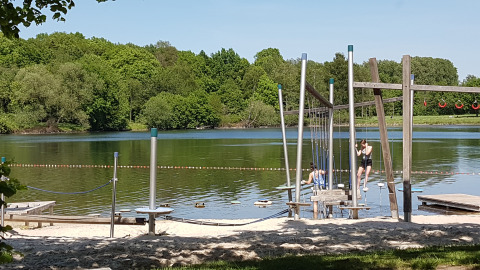 Strand met speeltoestellen en kinderen bij het water op Luxe Camping Borken am See - Glamping Noordrijn-Westfalen.