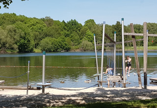 Badestrand mit Spielplatz und Kindern am Wasser bei Luxe Camping Borken am See - Glamping Noordrijn-Westfalen.