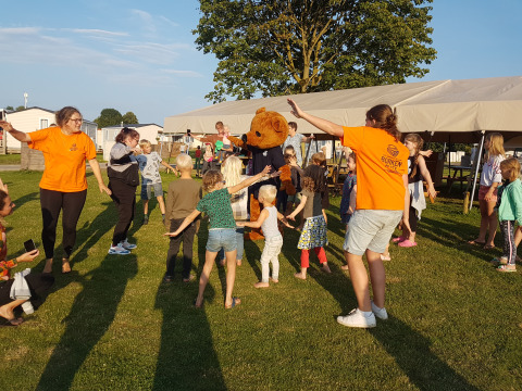 Children and adults play together outdoors at Luxe Camping Borken am See - Glamping Noordrijn-Westfalen.