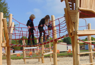 Kinder spielen auf einer Hängebrücke am Spielplatz von Luxe Camping Borken am See - Glamping Noordrijn-Westfalen.