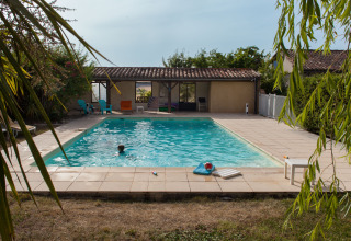 Piscine extérieure à Nature's Pace Holidays - Glamping Occitanie, avec terrasse, chaises et verdure autour.