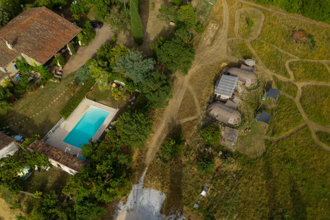 Vue aérienne de Nature's Pace Holidays - Glamping Occitanie avec piscine, verdure et tentes glamping