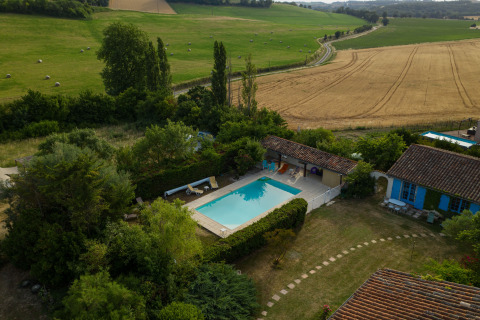 Luchtfoto van Nature's Pace Holidays - Glamping Occitanie met zwembad, velden en landhuis.