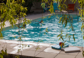 Outdoor pool at Nature's Pace Holidays - Glamping Occitanie, kids swimming, loungers and pool toys nearby.