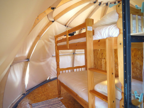 Interno di tenda glamping con letti a castello presso Nature's Pace Holidays - Glamping Occitanie, Francia.