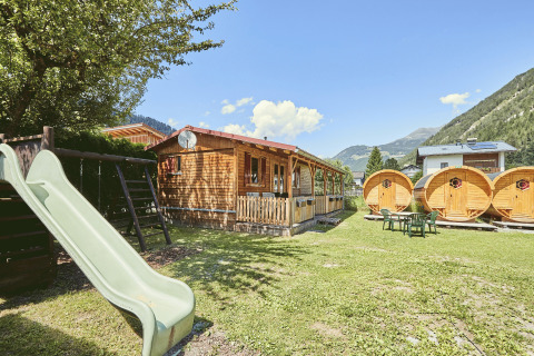Glamping al Camping Dreilandereck - Lodge & Wijnvat Tirol con casette, botti e area giochi tra le montagne.