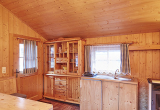 Innenansicht einer holzvertäfelten Glamping-Lodge bei Camping Dreiländereck - Lodge & Wijnvat Tirol, gemütliches Ambiente.