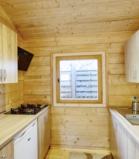 Små træbeklædte køkkenfaciliteter i glampingindkvartering på Camping Dreilandereck - Lodge & Wijnvat Tirol.