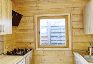 Compact wooden kitchen interior inside glamping accommodation at Camping Dreilandereck - Lodge & Wijnvat Tirol.