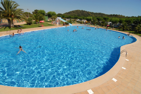 Large outdoor swimming pool with guests at Park Mas Patoxas – Bungalows Costa Brava glamping site.