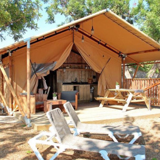 Hébergement glamping au Park Mas Patoxas – Bungalows Costa Brava avec terrasse, mobilier bois et transats.