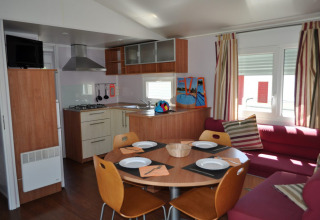 Interieur van de Park Mas Patoxas glamping accommodatie met keuken, eettafel en bank, Costa Brava.