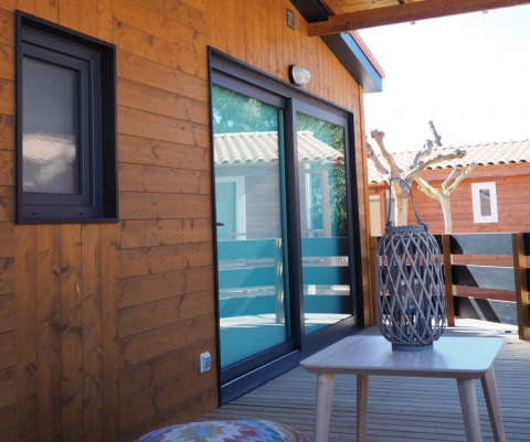 Houten bungalowterras met schuifdeuren en decoratie bij Park Mas Patoxas – Bungalows Costa Brava, camping.