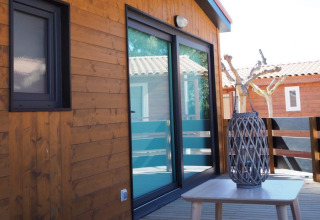 Wooden bungalow terrace with glass doors and stylish decor at Park Mas Patoxas – Bungalows Costa Brava.