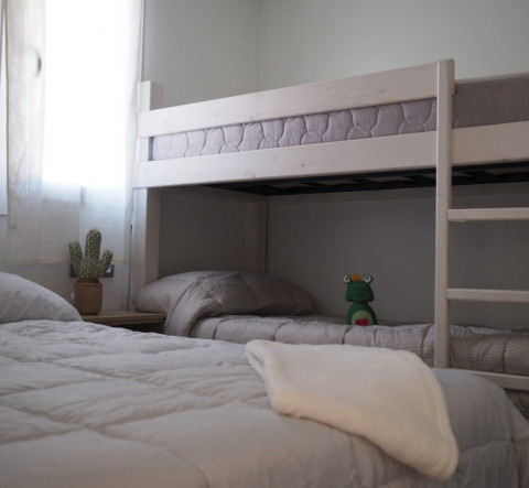 Kamer met stapelbed en eenpersoonsbed in Park Mas Patoxas – Bungalows Costa Brava glamping accommodatie.