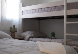 Habitación con litera y cama individual en Park Mas Patoxas – Bungalows Costa Brava alojamiento glamping.