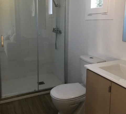 Bagno moderno presso Park Mas Patoxas – Bungalows Costa Brava con doccia, WC e lavandino elegante.
