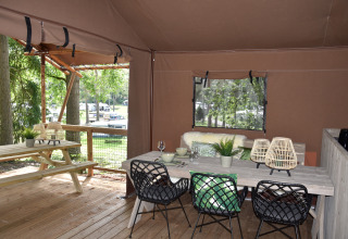 Hébergement glamping Camping Samoza avec coin repas confortable, déco moderne et vue sur la forêt.