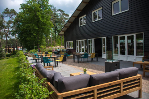 Udendørs terrasse på Camping Samoza – Glamping Lodges Veluwe med komfortable siddepladser og grøn udsigt.