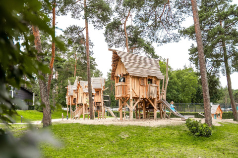Glamping-Lodges bei Camping Samoza auf der Veluwe, Holzspielhäuser mit Kindern in natürlicher Umgebung.
