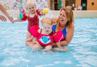 Mother and two young children enjoy the swimming pool with floaties at Camping Samoza – Glamping Lodges Veluwe.
