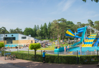 Piscina exterior con toboganes de agua y personas disfrutando en Camping Samoza – Glamping Lodges Veluwe.