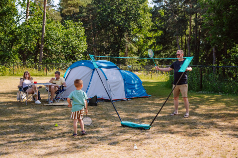 Familie spielt Badminton und entspannt vor einem Zelt bei Camping Samoza – Glamping Lodges Veluwe.