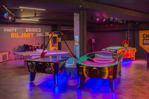 Sala giochi interna al Camping Samoza – Glamping Lodges Veluwe con tavoli da air hockey e giochi arcade.