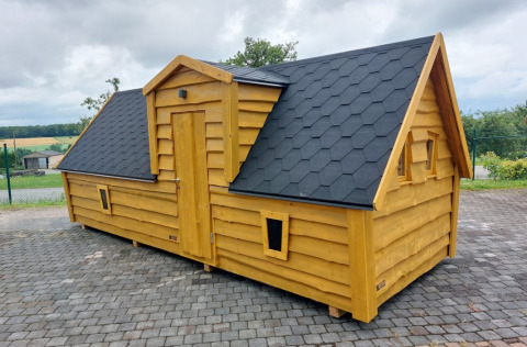 Et eventyragtigt træhytte glampinghus ved Camping Rissbach i Rheinland-Pfalz, Tyskland, med sort tag.