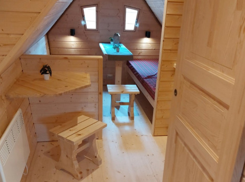 Houten interieur van glamping accommodatie met bed bij Camping Rissbach - Sprookjeshuis Rijnland-Palts.