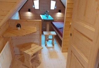 Houten interieur van glamping accommodatie met bed bij Camping Rissbach - Sprookjeshuis Rijnland-Palts.