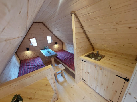 Interno glamping presso Camping Rissbach - Sprookjeshuis Rijnland-Palts con letti gemelli in legno.